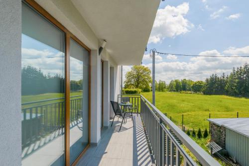 a balcony with a view of a green field at APARTAMENTY PIAMOLA Willa Zacisze Kąty Rybackie in Kąty Rybackie