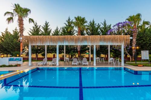a pool at a resort with chairs and a gazebo at VISTA Villa in Belek