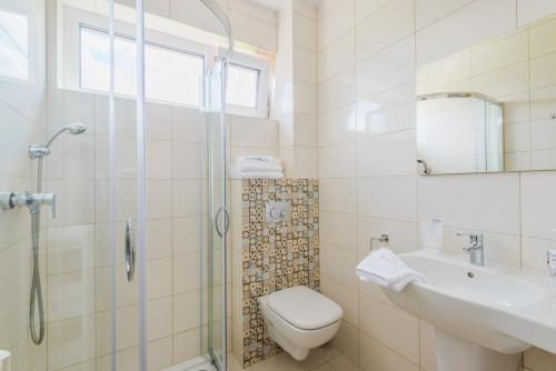 a bathroom with a shower and a toilet and a sink at APARTAMENTY PIAMOLA Willa Zacisze Kąty Rybackie in Kąty Rybackie