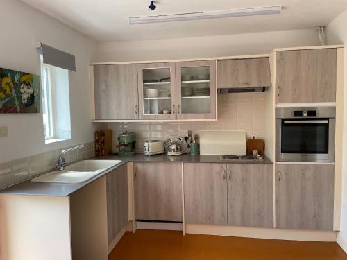 uma cozinha com armários de madeira, um lavatório e um micro-ondas em Top Studio em Lincoln