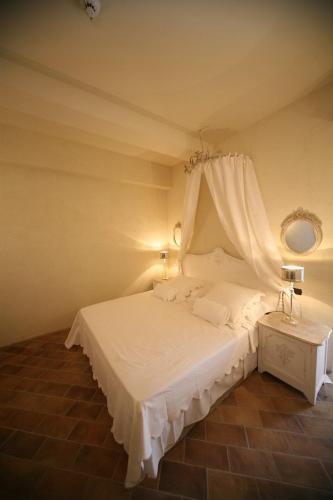 a bedroom with a white bed with a canopy at Il Poggio Country Resort in Graniti