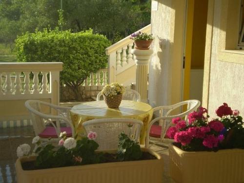 a table and chairs with flowers on a porch at Apartments Kampor (4235) in Kampor