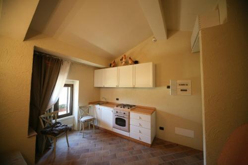 a small kitchen with a stove and white cabinets at Il Poggio Country Resort in Graniti