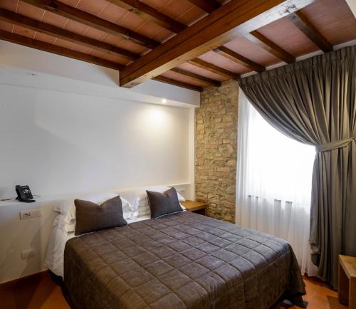 a bedroom with a large bed and a window at Tenuta Sovestro - Agriturismo e winery in San Gimignano