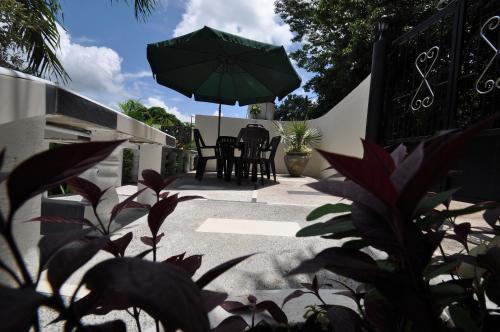 a patio with a table and an umbrella at Chrisent Residence in Port Glaud