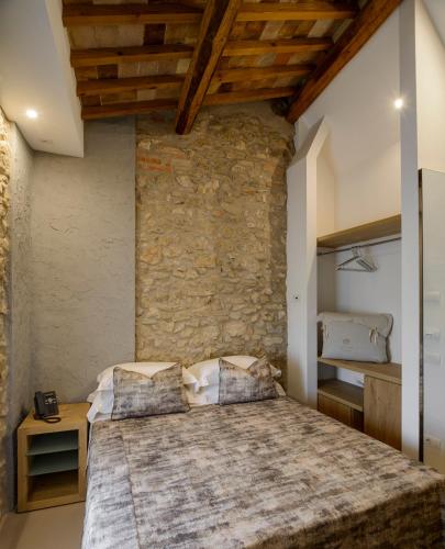 a bedroom with a large bed and a stone wall at Tenuta Sovestro - Agriturismo e winery in San Gimignano