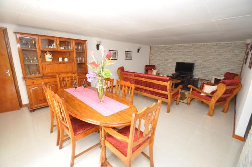 a dining room with a wooden table and chairs at Chrisent Residence in Port Glaud