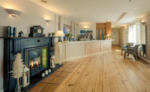 a living room with a fireplace and a kitchen at Dingle Harbour Lodge B&B in Dingle