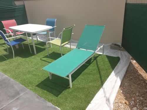 une table et des chaises et un banc bleu sur l'herbe dans l'établissement Studio contemporain proche de toutes les plages, à Villeneuve-lès-Maguelone