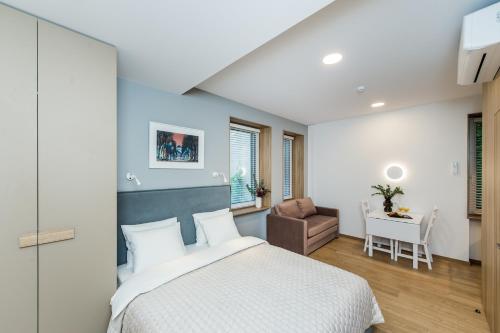 1 dormitorio con cama, silla y escritorio en River city apartments No 1 by URBAN RENT, en Kaunas