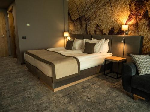 a bedroom with a large bed and a couch at The Five Elements Hotel and SPA in Sapareva Banya