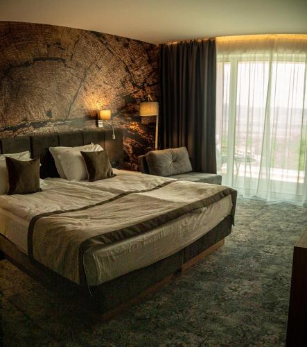 a bedroom with a large bed and a large window at The Five Elements Hotel and SPA in Sapareva Banya