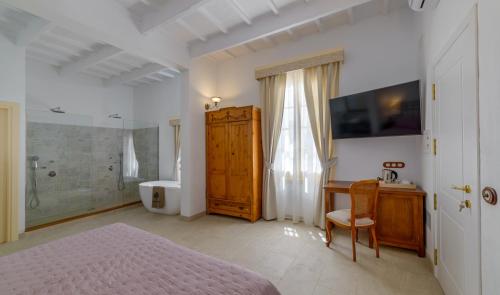 a bedroom with a bed and a desk and a bathroom at Seranova Luxury Hotel - Adults Only in Ciutadella