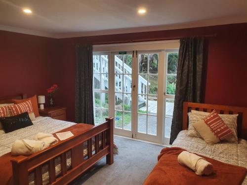 a bedroom with two beds and a large window at Koromatua Homestead in Whatawhata