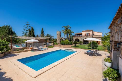a swimming pool in a yard with a house at Es Voltor in Artá