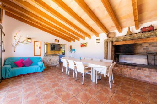 a living room with a table and a fireplace at Es Voltor in Artá