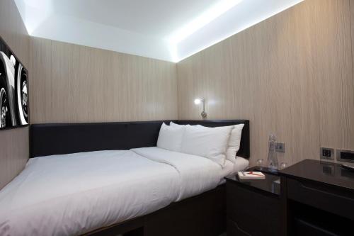 a bedroom with a large bed with white sheets at The Z Hotel Glasgow in Glasgow