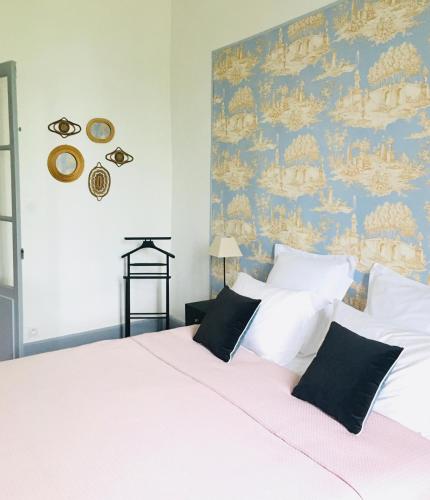 a bedroom with a large white bed with a blue wall at Le Domaine de Villespy in Villespy