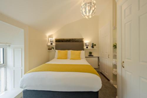 a bedroom with a large bed with yellow pillows at The Waterfront in Dingle