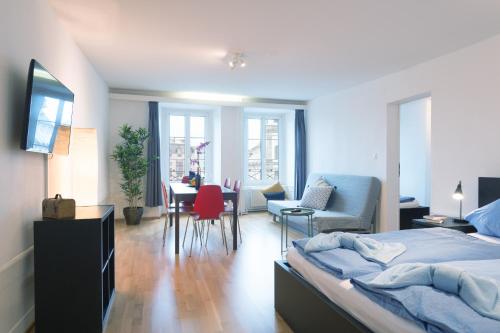 a bedroom with a bed and a table and chairs at HITrental Chapel Bridge Apartments in Lucerne