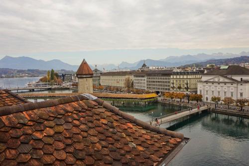 a view of a city with a river and buildings at HITrental Chapel Bridge Apartments in Luzern