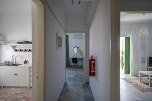 a white kitchen with a fire extinguisher on the wall at Kima Skiathos in Megali Ammos