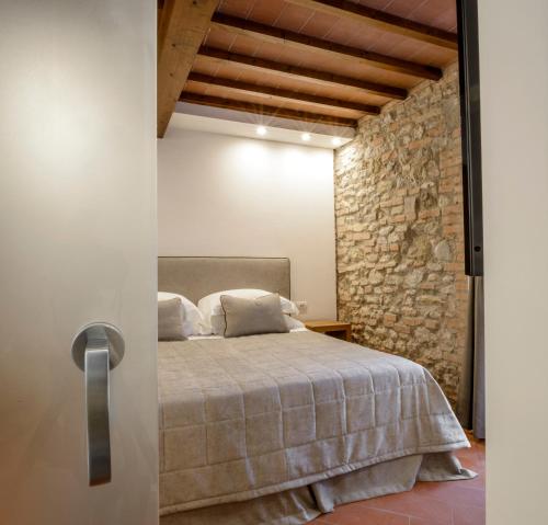 a bedroom with a bed and a stone wall at Tenuta Sovestro - Agriturismo e winery in San Gimignano