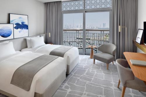 a hotel room with two beds and a desk at Vida Creek Harbour in Dubai