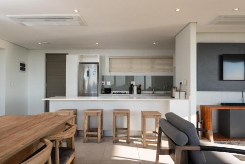 una cocina abierta con mesa de madera y sillas en 254 Ocean Dune Sibaya, en Umhlanga