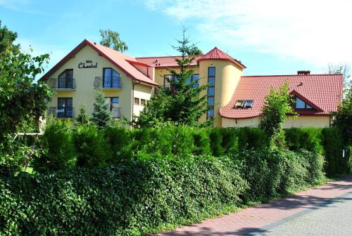 a building with a hedge in front of a street at Willa Chantal in Jastrzębia Góra