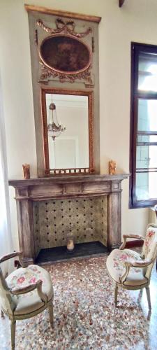 a living room with a mirror and two chairs at Palazzo Mantua Benavides Suites & Apartments in Padova