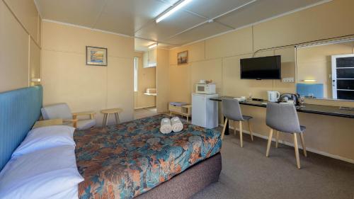 a hotel room with a bed, desk and television at Matilda Motel in Winton