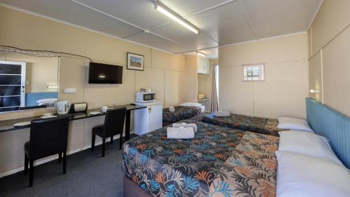 a hotel room with a couch and a table and chairs at Matilda Motel in Winton