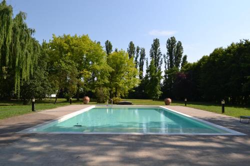 a swimming pool in the middle of a park at La Locanda nel Frutteto in Rovereto