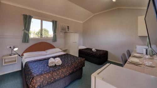 a hotel room with a bed with shoes on it at Matilda Motel in Winton
