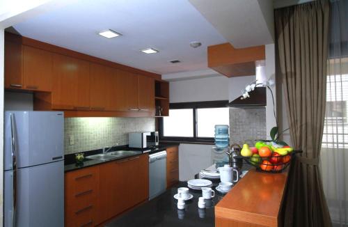 
a kitchen with a stove, refrigerator, sink, and dishwasher at The Sultan Hotel & Residence Jakarta in Jakarta
