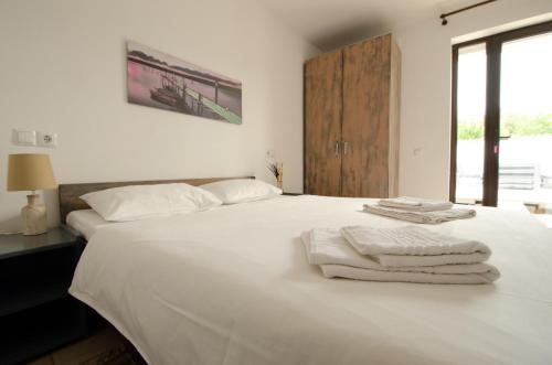 una camera da letto con un letto bianco con asciugamani sopra di Opera Vama Veche a Vama Veche