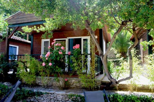 a house with a tree and flowers in front of it at Résidence L'araguina in Bonifacio