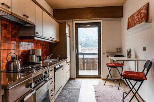 a kitchen with a counter and a table with chairs at Residence Greymold in Rifiano