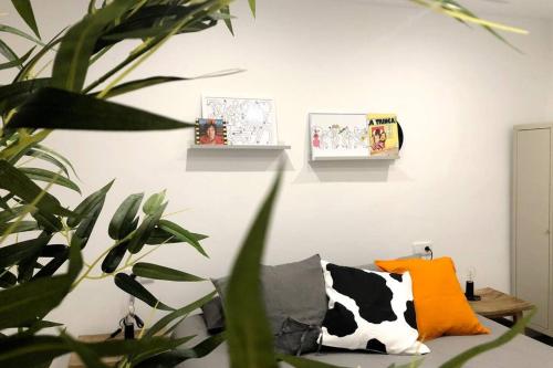 a living room with a couch with a cow pillow at M5 Cool Terrace. Metro 1 min. Center 15' by metro in Esplugues de Llobregat