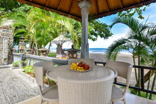un bol de fruta sentado en una mesa en una playa en Villa Spice House Inn Downstair, en Lovina