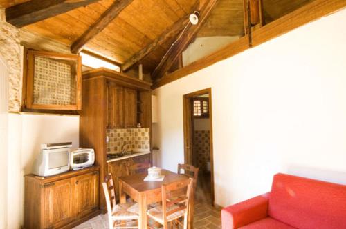 a kitchen with a red couch and a table with a microwave at Agriturismo I Sassi Grossi in Corciano