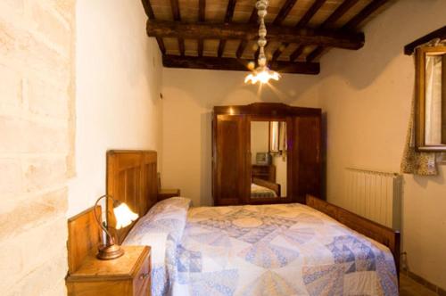 1 dormitorio con 1 cama y 1 lámpara en una mesa en Agriturismo I Sassi Grossi, en Corciano