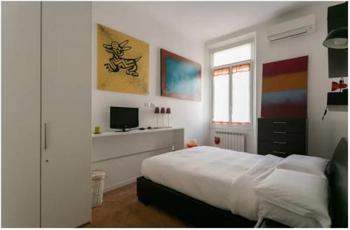 a white bedroom with a bed and a television at Splendido Bilocale in Via Orti - A pochi metri dal Policlinico in Milan