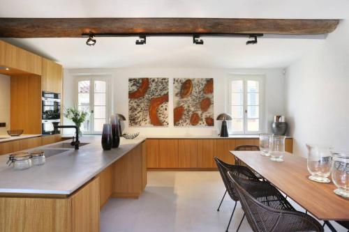 une cuisine avec des armoires en bois et une table avec des chaises dans l'établissement Maison Skyloft, à Saint-Tropez