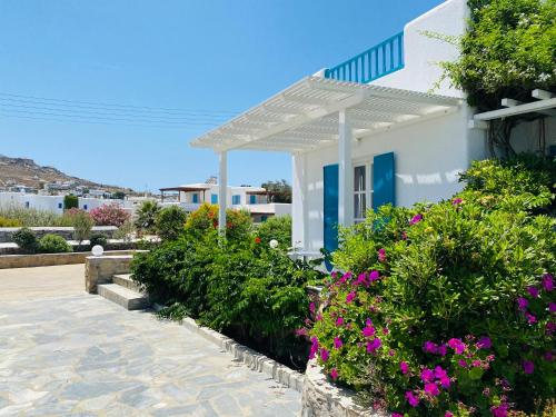 a white house with flowers in front of it at Cyclades Blue in Ornos