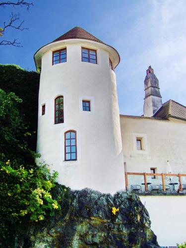 Un edificio bianco con una torre sopra. di Haus zum Nibelungenlied a Melk