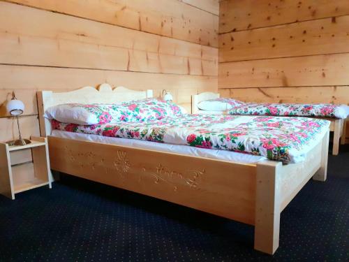 a bed in a room with a wooden floor at Willa Wierzbówka in Witów