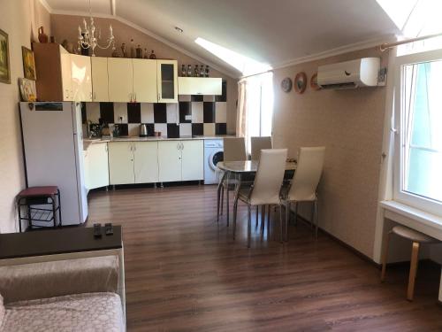 een keuken en een woonkamer met een tafel en stoelen bij Pod evkaliptom Apartment in Gagra