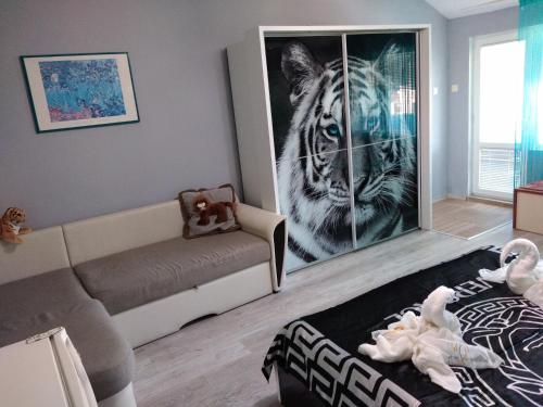 a living room with a couch and a tiger picture at Къща за гости Синьо Лято in Pomorie